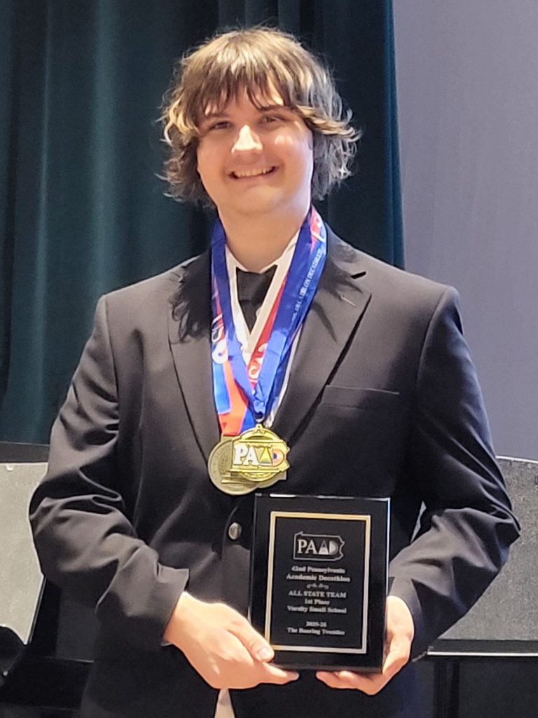 Photo taken on March 14. Reese Peterson poses with his first place medals and plaque after winning the varsity state competition. Photo taken by Mitch Hart.